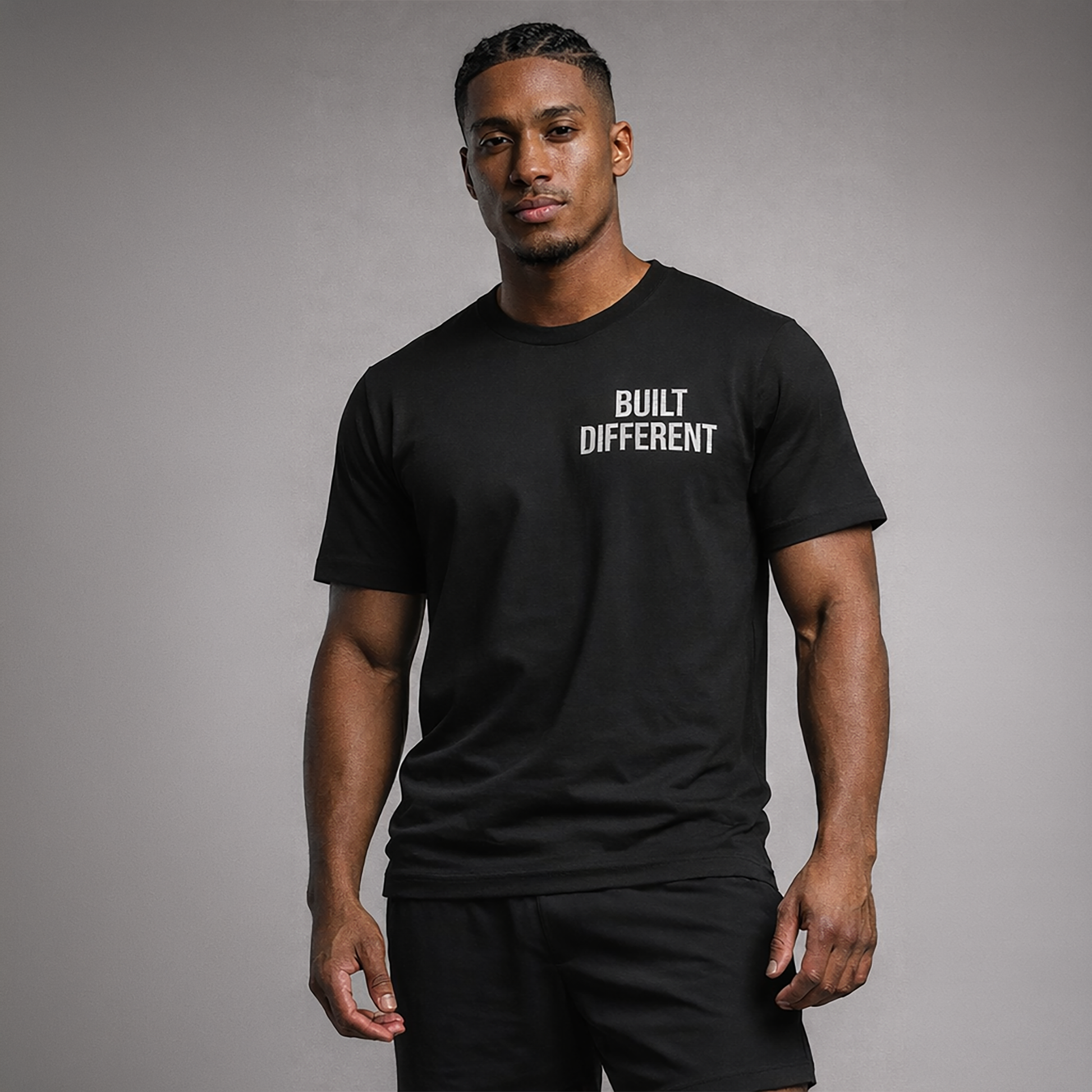 Man wearing a black t-shirt with 'BUILT DIFFERENT' text on a gray background