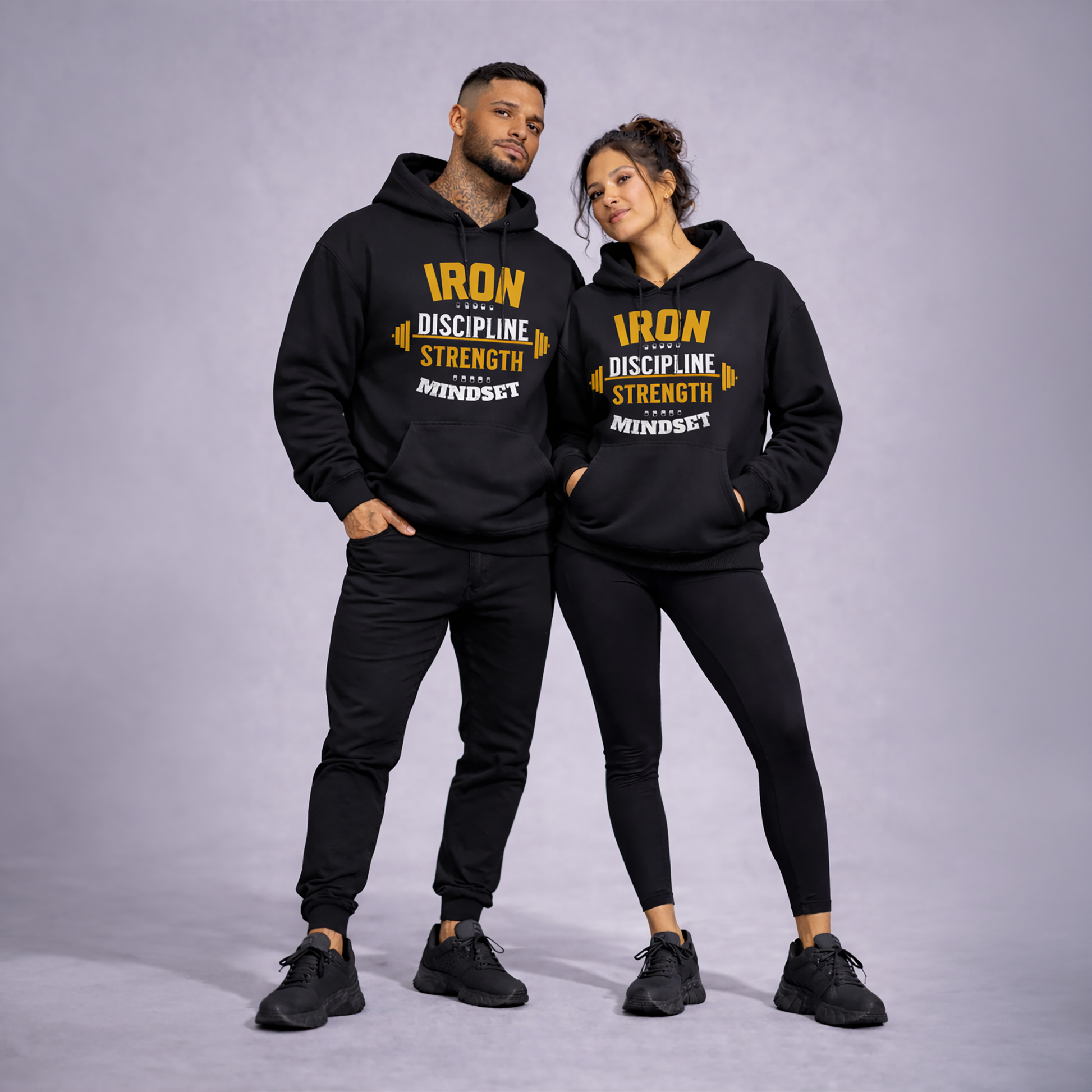 Two people wearing matching black hoodies with yellow text on a gray background