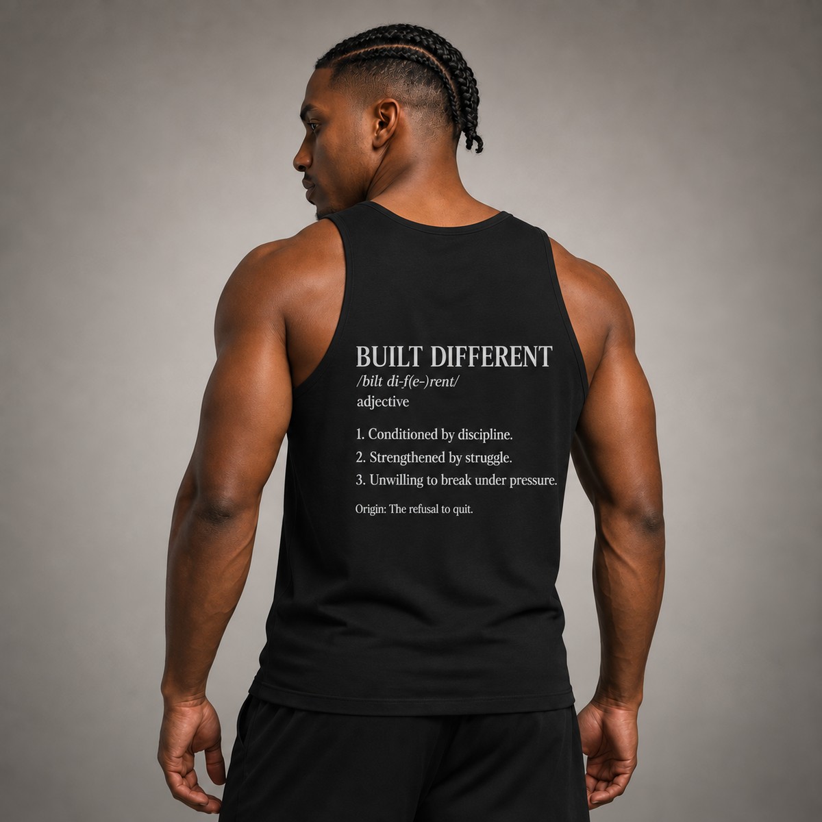 Man wearing a black tank top with 'Built Different' text on the back against a gray background
